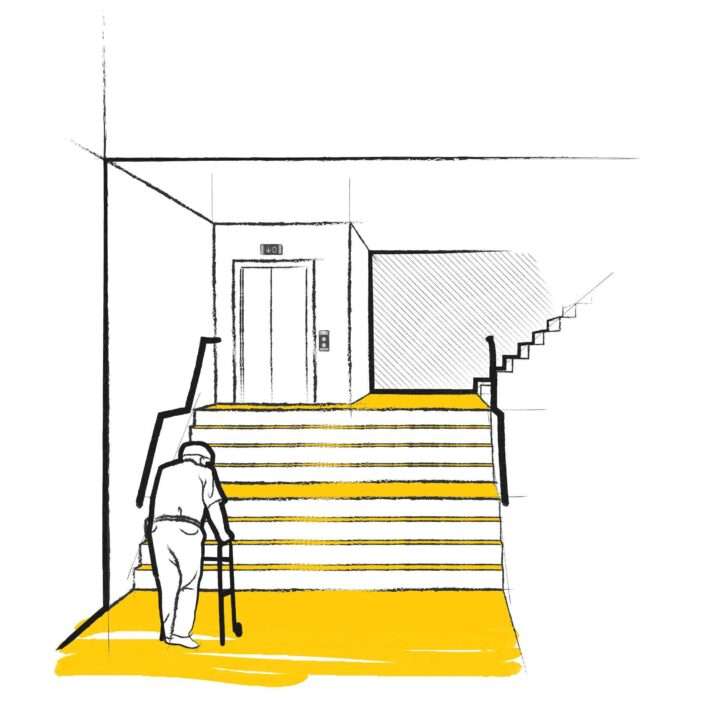 Personne en fauteuil roulant entrant dans un ascenseur équipé d'un cadre jaune, avec une signalisation au-dessus de la porte et un panneau de contrôle à droite.