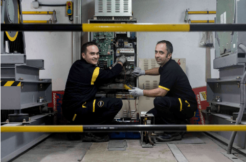 Deux techniciens d'ascenseur en train de travailler