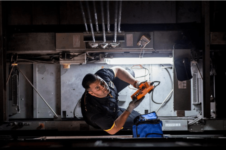 Technicien FAIN utilisant un gant anti-coupure pour des tâches techniques en milieu industriel.