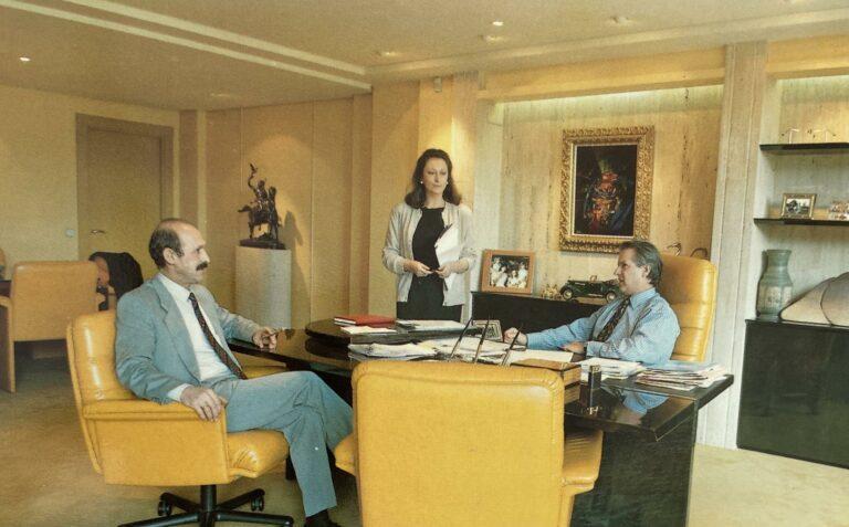 Trois personnes dans un bureau moderne à Madrid, entourées de meubles élégants et d’éléments décoratifs.