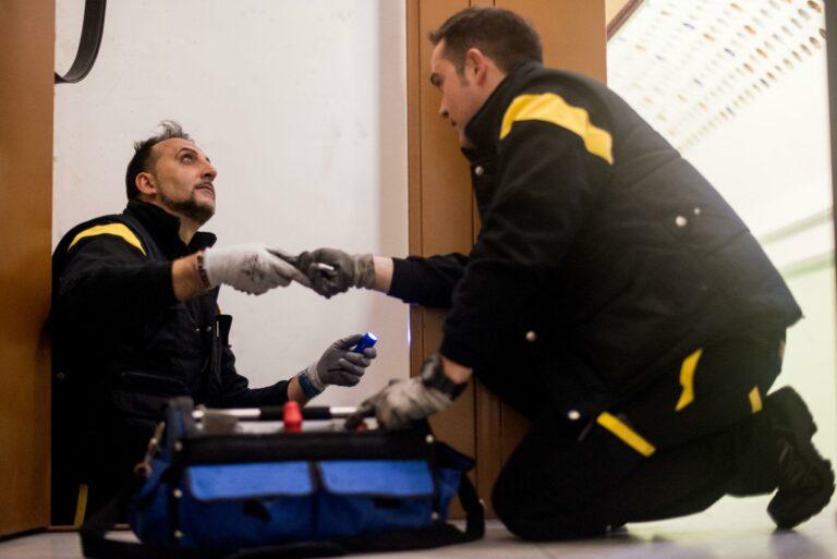 Technicien FAIN utilisant un gant anti-coupure pour des tâches techniques en milieu industriel.