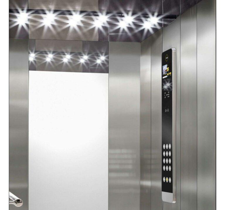Une femme appuie sur un bouton à l’intérieur d’un ascenseur moderne.