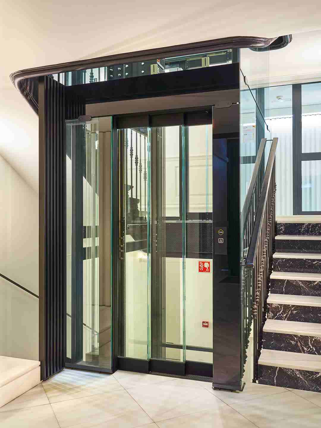 ascenseur en verre dans un cage d'escalier 