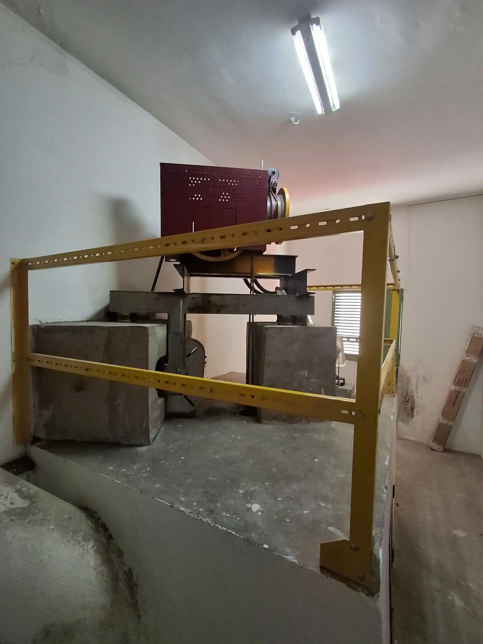Socle en béton sur lequel repose le moteur d’un ascenseur